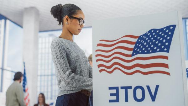 Young black woman at a voting booth.